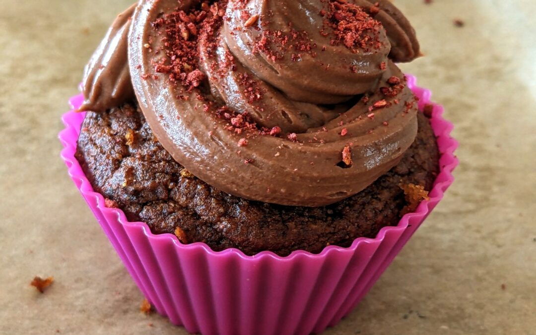 Berry Cupcake. Delicious, nutritious. It is plant based and refined sugar free. That powder on top is raspberry. A “chocolate” frosting and blueberry filling.
