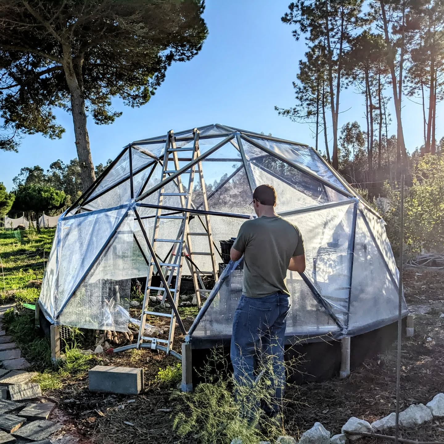 Rebuilding the greenhouse cover with help from our guests.