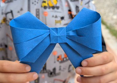 Child holds an origami bow